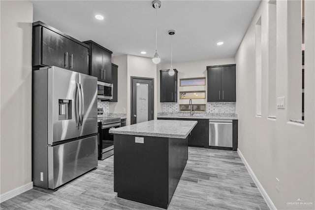 kitchen featuring backsplash, a center island, hanging light fixtures, and appliances with stainless steel finishes