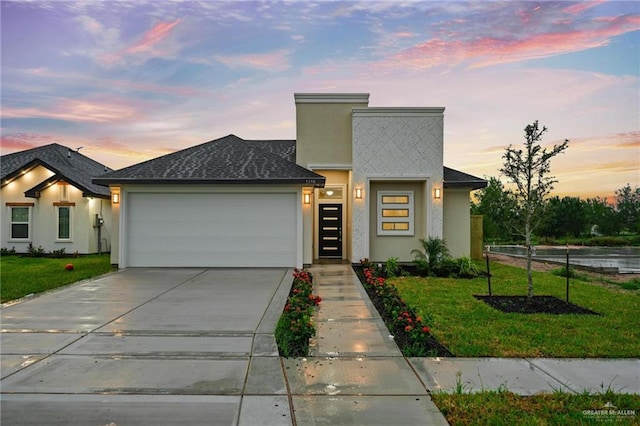 view of front of home with a garage and a lawn