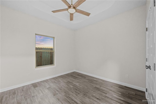 spare room featuring wood-type flooring and ceiling fan