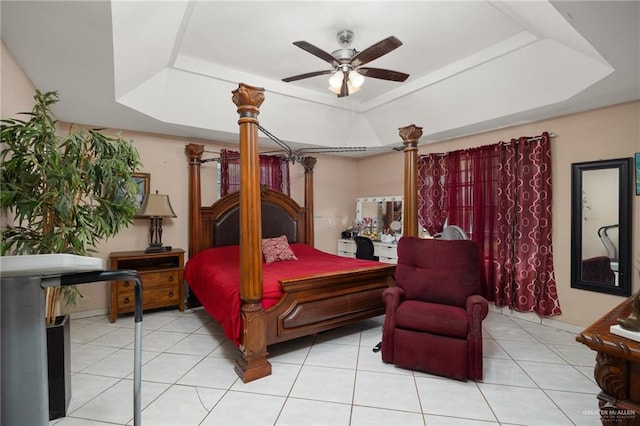 tiled bedroom featuring a raised ceiling and ceiling fan