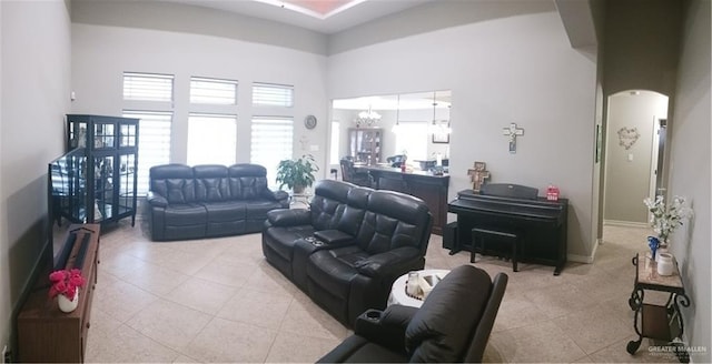 1805 Black Stone St, Edinburg, TX 78542 - living room with arched walkways, a towering ceiling, tile patterned flooring, and a chandelier