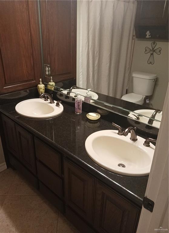 1805 Black Stone St, Edinburg, TX 78542 - bathroom with double vanity, tile patterned floors, and toilet