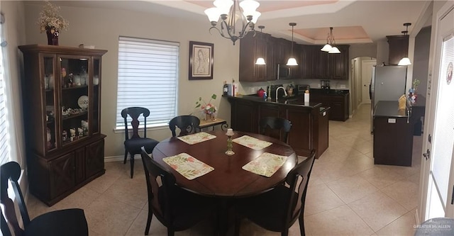1805 Black Stone St, Edinburg, TX 78542 - dining room with a tray ceiling, a chandelier, light tile patterned flooring, and baseboards