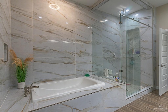 bathroom featuring separate shower and tub and tile walls