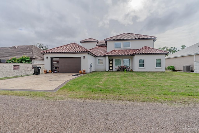 mediterranean / spanish house featuring a front yard, central AC, and a garage