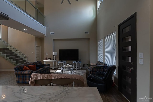 living room with hardwood / wood-style flooring and a towering ceiling