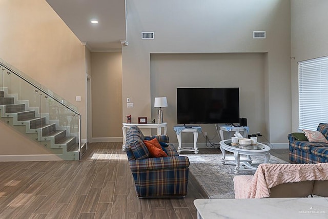 living room featuring wood-type flooring and a towering ceiling