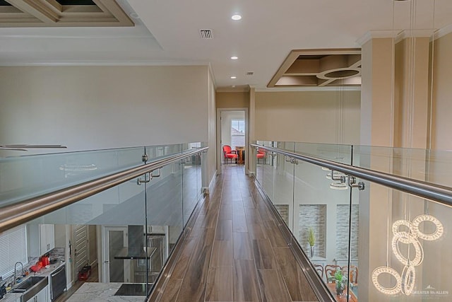 hallway with dark hardwood / wood-style floors, ornamental molding, and sink