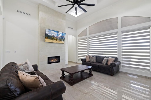 22303 Uresti Rd, Edinburg, TX 78542 - living area featuring ceiling fan, a tile fireplace, a towering ceiling, and ornamental molding