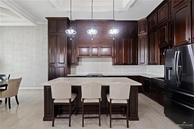 22303 Uresti Rd, Edinburg, TX 78542 - kitchen featuring stainless steel fridge, a center island, tasteful backsplash, light countertops, and a breakfast bar