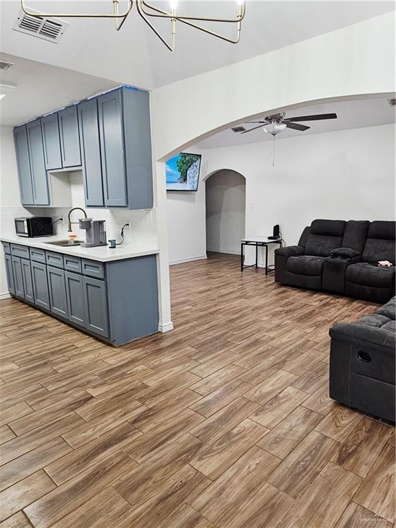 912 Max Dr, Elsa, TX 78543 - living area with a ceiling fan, arched walkways, light wood-type flooring, and a chandelier