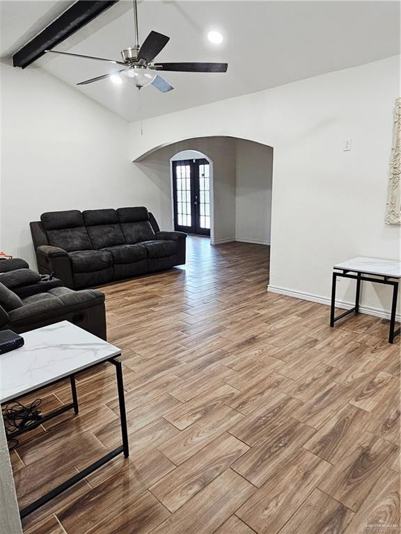 912 Max Dr, Elsa, TX 78543 - living area with arched walkways, a ceiling fan, light wood-style floors, baseboards, and french doors