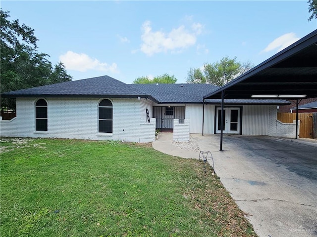 912 Max Dr, Elsa, TX 78543 - back of property featuring french doors, brick siding, roof with shingles, and concrete driveway