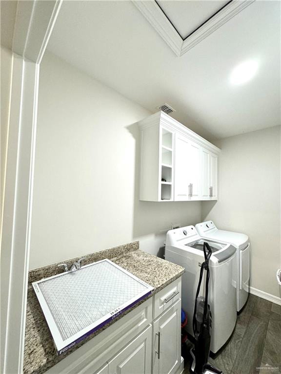 clothes washing area with separate washer and dryer, cabinets, and dark hardwood / wood-style floors