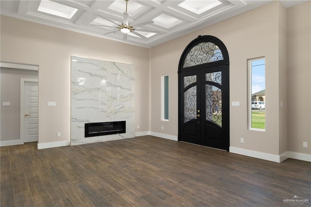 entrance foyer featuring french doors, coffered ceiling, a high end fireplace, beamed ceiling, and dark hardwood / wood-style floors