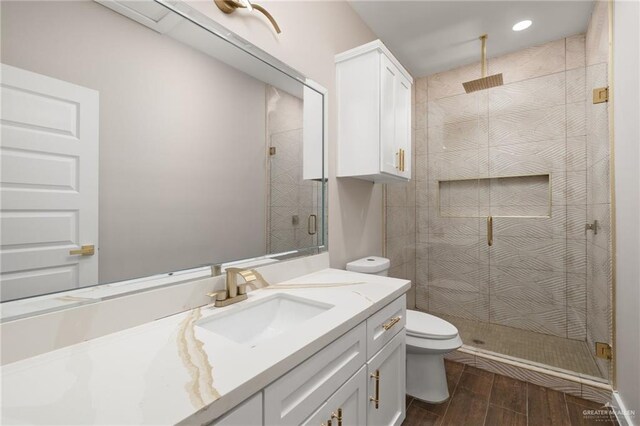 bathroom featuring toilet, vanity, wood-type flooring, and walk in shower