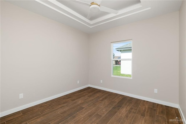 unfurnished room featuring dark hardwood / wood-style flooring, a raised ceiling, and ceiling fan