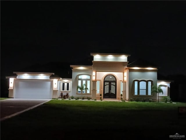 view of front of house with a lawn, french doors, and a garage