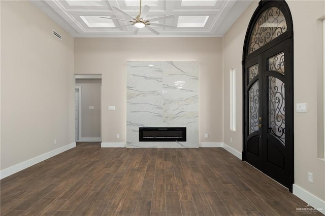 entrance foyer featuring ceiling fan, dark hardwood / wood-style flooring, a high end fireplace, and coffered ceiling