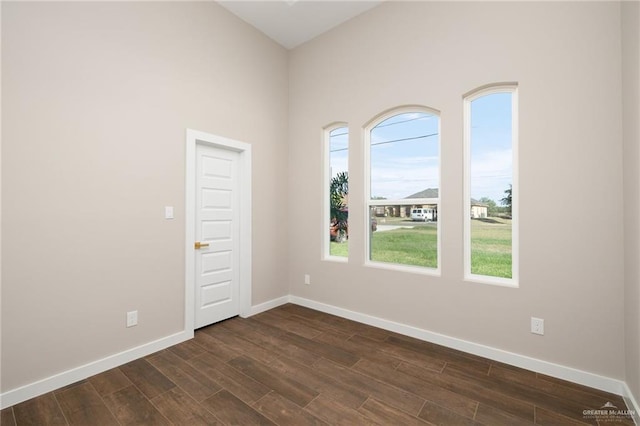 unfurnished room with plenty of natural light and dark hardwood / wood-style floors