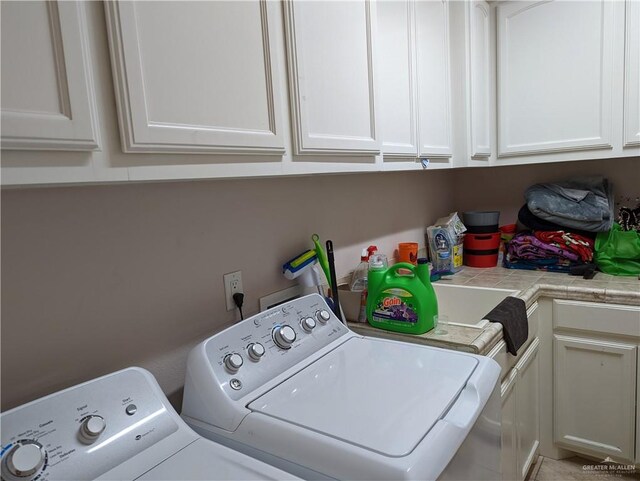 clothes washing area featuring cabinets and separate washer and dryer