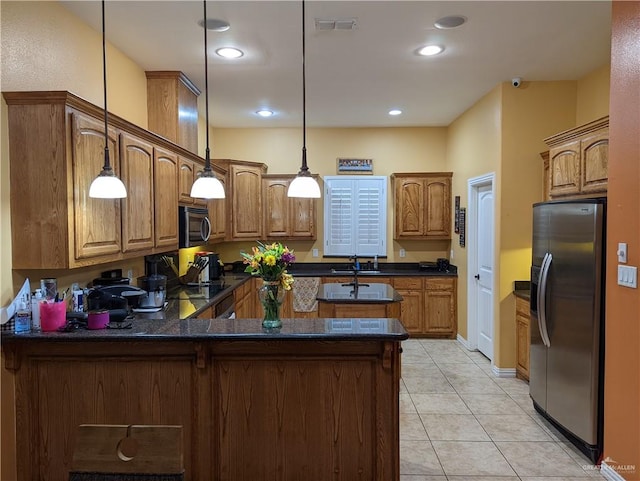 kitchen with kitchen peninsula, appliances with stainless steel finishes, pendant lighting, and light tile patterned flooring