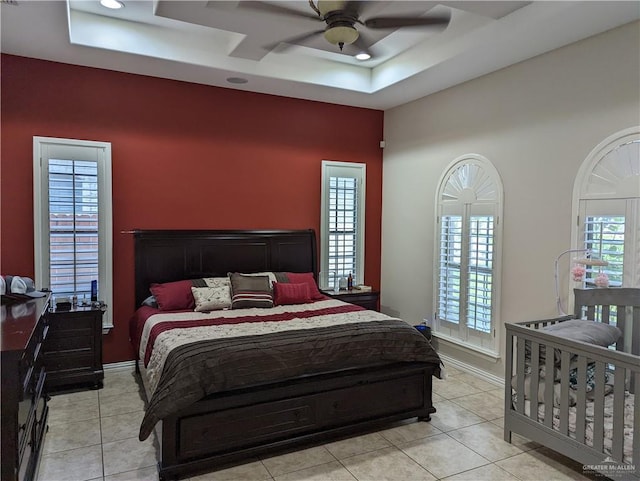 bedroom with light tile patterned floors, multiple windows, and ceiling fan