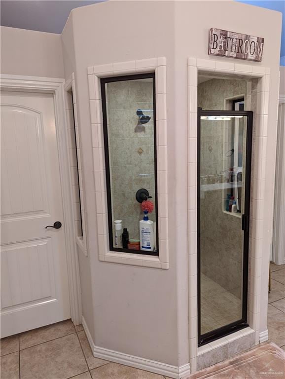 bathroom with tile patterned flooring and a shower with door