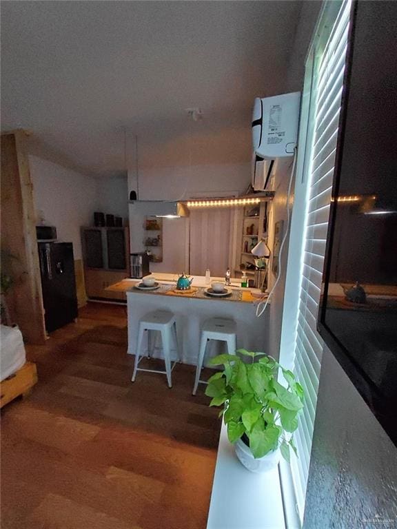 kitchen with hardwood / wood-style flooring and a breakfast bar area