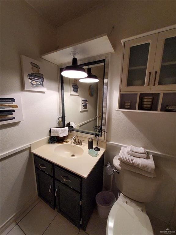 bathroom featuring tile patterned flooring, vanity, and toilet