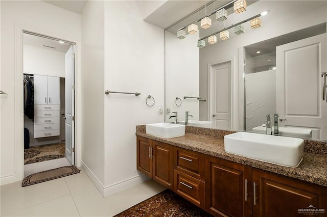 2408 Holland Ave, Edinburg, TX 78539 - bathroom featuring double vanity, tile patterned floors, baseboards, and a shower with door