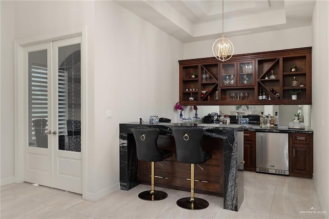 4552 Estancia Pkwy, Mcallen, TX 78504 - indoor wet bar featuring light tile patterned floors, a chandelier, pendant lighting, and a raised ceiling