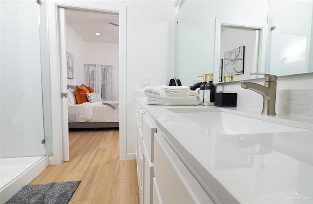 bathroom featuring a shower, vanity, and wood-type flooring