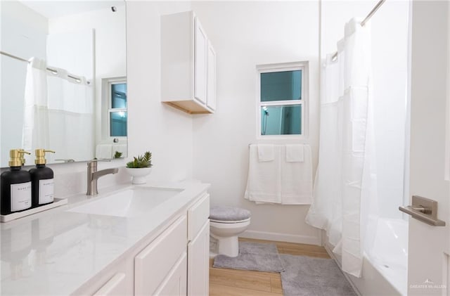 full bathroom with shower / bath combo with shower curtain, vanity, wood-type flooring, and toilet