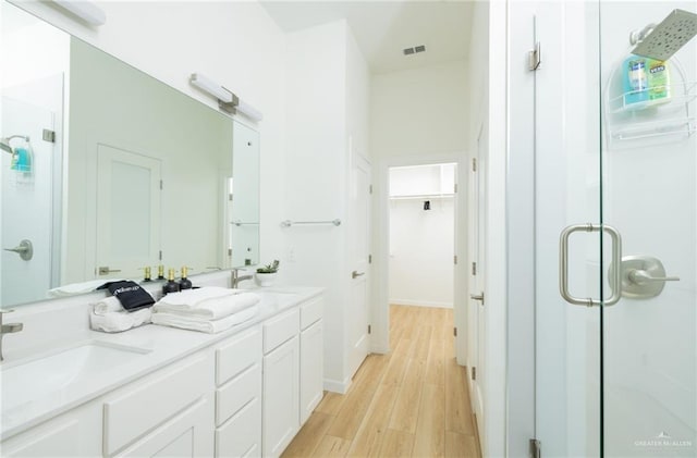 bathroom featuring wood-type flooring, vanity, and walk in shower