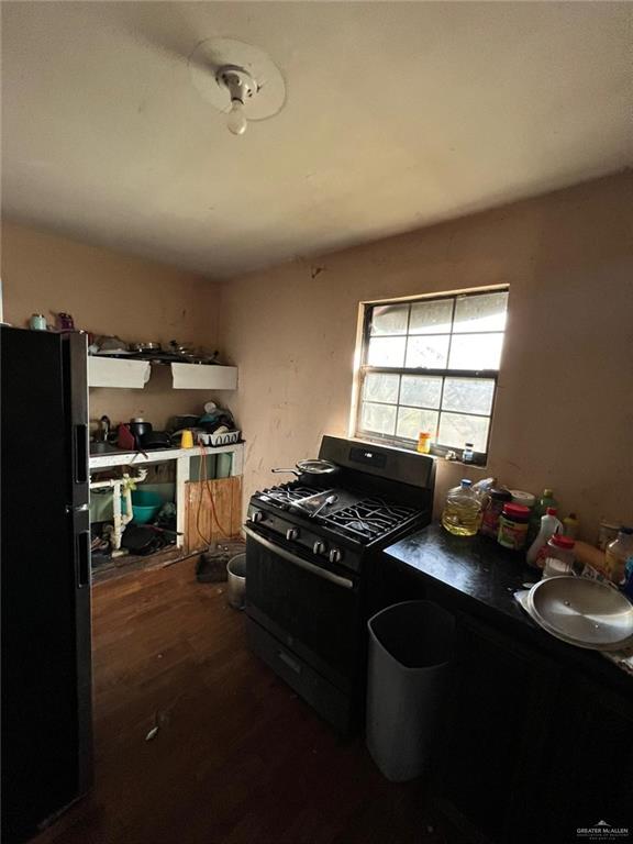 kitchen featuring black range with gas stovetop, sink, and dark hardwood / wood-style floors