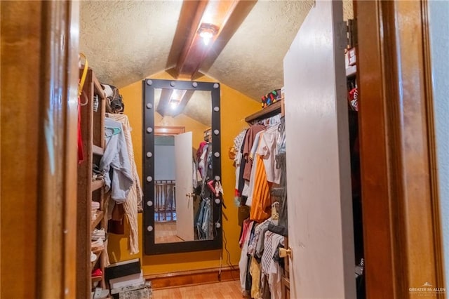 walk in closet with light hardwood / wood-style flooring and vaulted ceiling