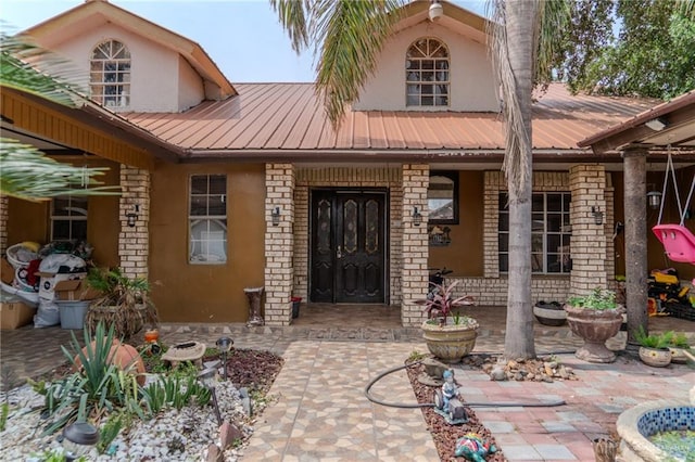 view of exterior entry with a patio area