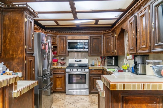 kitchen with appliances with stainless steel finishes, light tile patterned floors, and sink