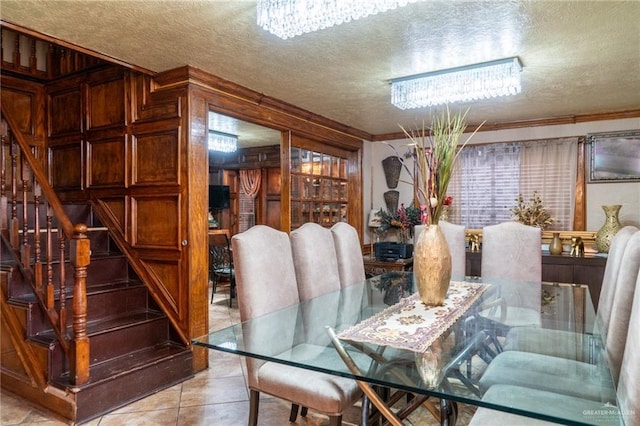 dining room with crown molding, light tile patterned floors, a textured ceiling, and a notable chandelier