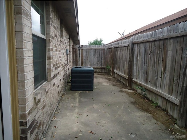 view of side of home with cooling unit and a patio