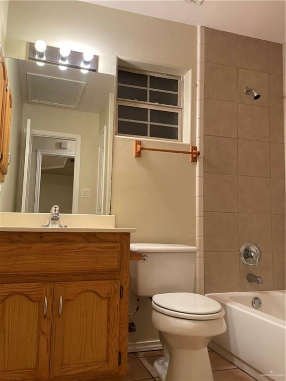 full bathroom with tile patterned floors, vanity, tiled shower / bath, and toilet