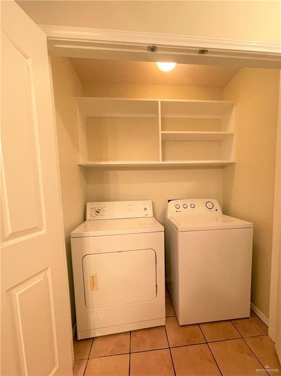 laundry area featuring washing machine and dryer and light tile patterned flooring