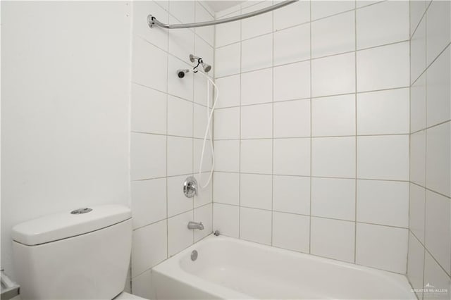 bathroom with toilet and tiled shower / bath