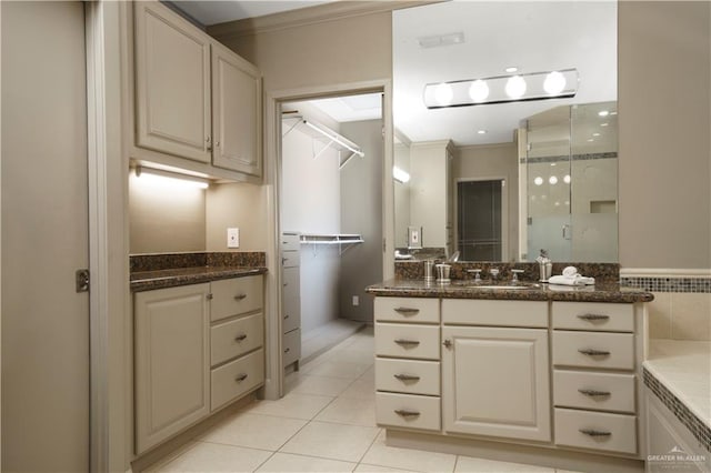 bathroom with tile patterned flooring, vanity, a shower with shower door, and ornamental molding