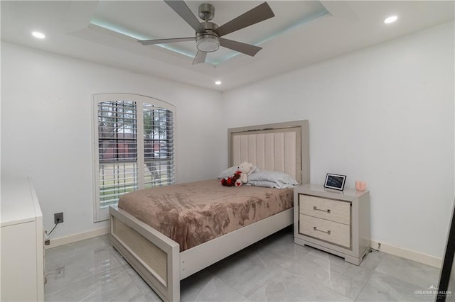 bedroom with a raised ceiling and ceiling fan