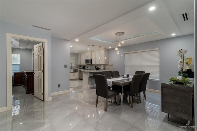 dining room featuring a raised ceiling