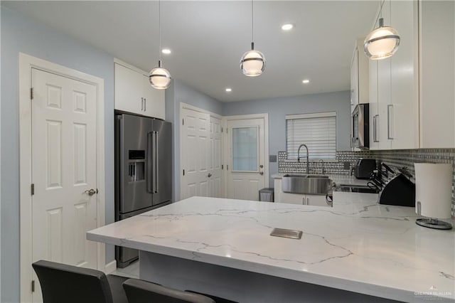 kitchen with white cabinetry, sink, hanging light fixtures, and stainless steel appliances