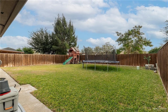 view of yard featuring a playground and a trampoline