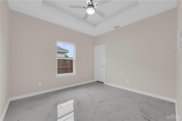 3007 S Livingston St, Edinburg, TX 78542 - spare room with marble look tiles, a tray ceiling, ceiling fan, and baseboards